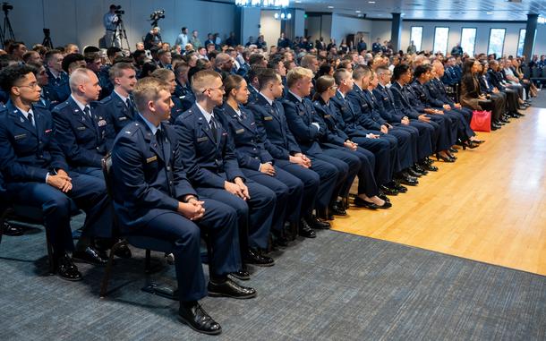 Rows of people seated in Space Force uniforms in an auditorium.