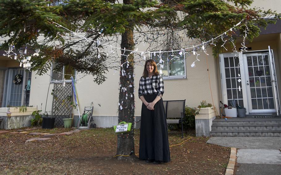 Annastasha Larsen, creator of a wishing tree, poses outside her home at Yokota Air Base, Japan, on Dec. 20.