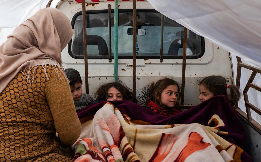 Yasmin, 30, tends to neighbor children left homeless in Jinderis. All of them are sleeping in a truck.