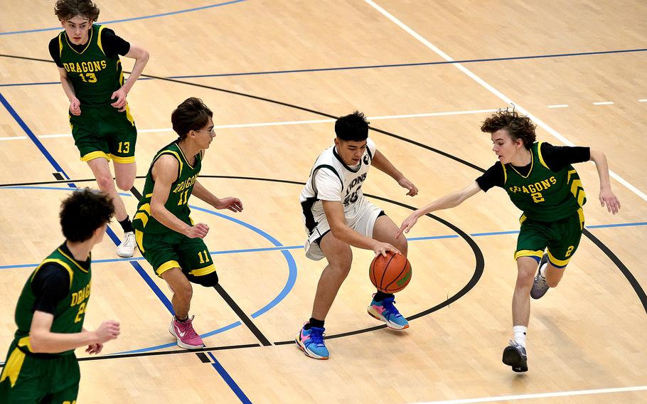 AFNORTH senior Anthony Romar keeps control of the ball as Alconbury’s Alfonso Sanchez, center left, and Vincent Sheehan, right, try to make the steal during pool-play action of the DODEA European basketball championships on Feb. 14, 2024, at the Wiesbaden Sports and Fitness Center on Clay Kaserne in Wiesbaden, Germany.
