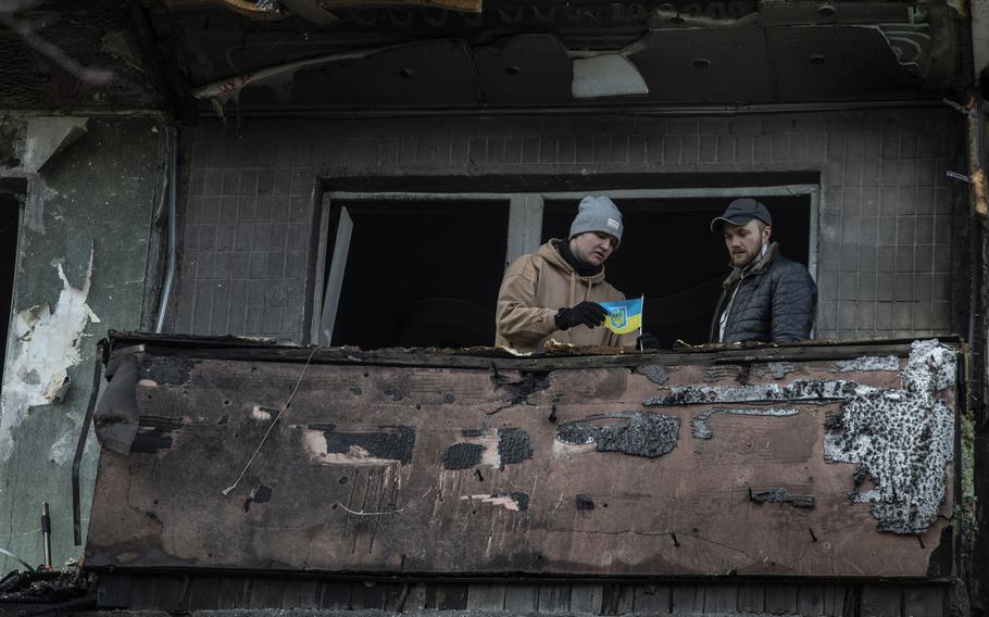 People on the balcony of a building in Kyiv's Obolon district, hit by a Russian strike on March 14, 2022. 