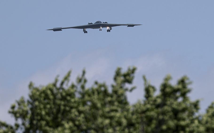 A stealth bomber flies over the treeline on its way home.