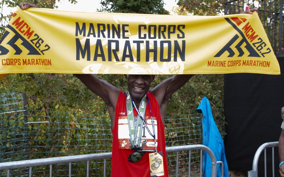 Julius Kogo holds the finish tape after winning the 48th Marine Corps Marathon, Sunday on Oct. 29, 2023, in Arlington, Va.