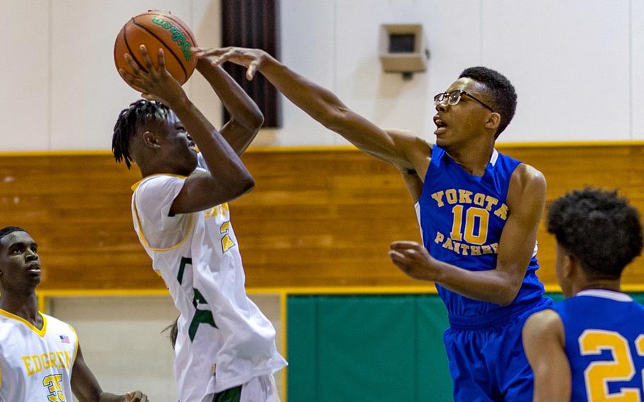 Robert D. Edgren's Messai Cain has his shot contested by Yokota's Arion Johnson during Friday's DODEA-Japan basketball game. The Panthers won 55-28.