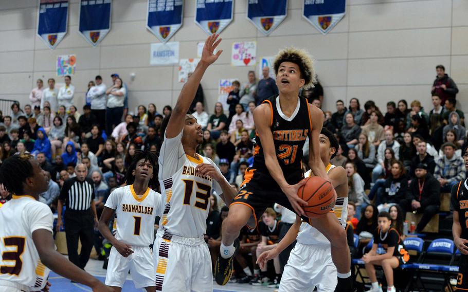 Spangdahlems Cameron Lewis looks for the basket as Baumholders defends  in the Division III championship game at the DODEA-Europe basketball finals in Ramstein, Germany, Feb. 18, 2023. Baumholder won 40-27 to take the title.