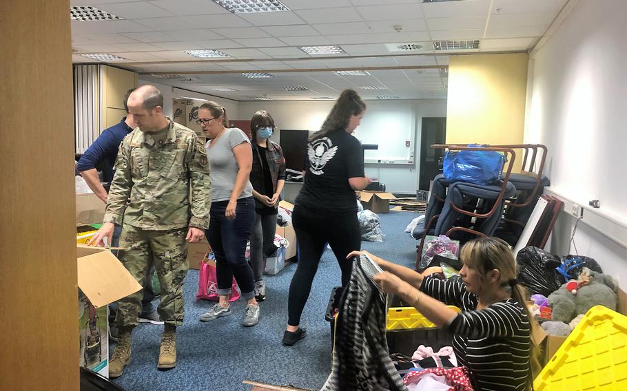 Andrew Wilder, an Air Force first sergeant, front left, and half a dozen volunteers from the Kaiserslautern military community sort through donated goods at Ramstein Air Base, Germany, August 19, 2021. Donations were made been collected for evacuees from Afghanistan, who were expected to arrive at the base. 