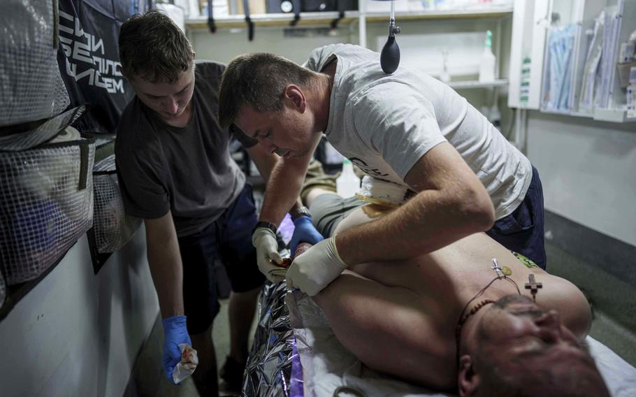 A medic treats a man’s drone strike injuries.