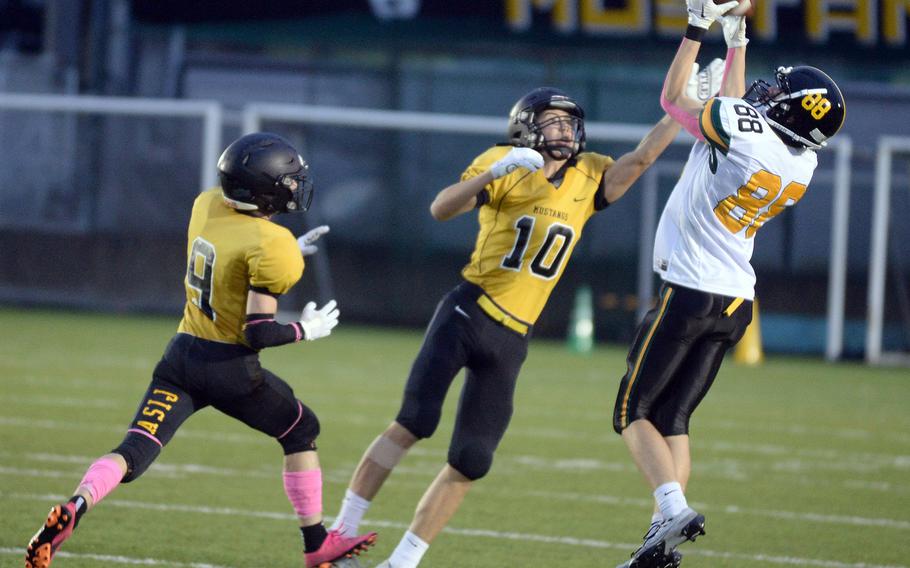 Robert D. Edgren receiver Gabriel Simmons tries to outleap American School In Japan defenders Jay Dossor and Gregor Rolls for a pass. The attempt went through Simmons' hands incomplete.