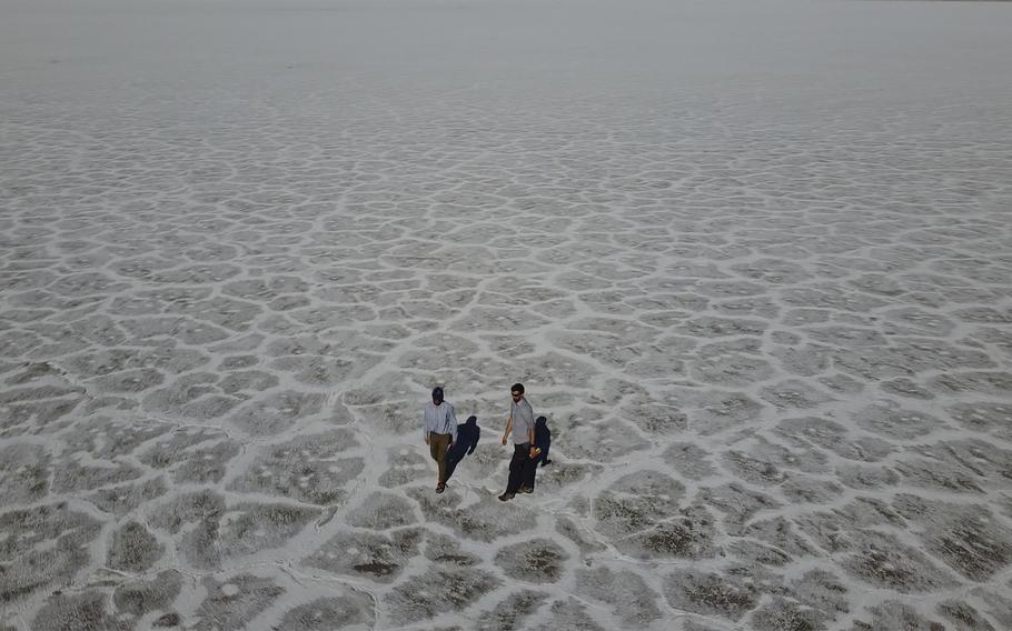 State of Utah Department of Natural Resources geologists Paul Inkenbrandt, left, and Jeremiah Bernau walk along the Bonneville Salt Flats on Aug. 29, 2022, near Wendover, Utah. The glistening white salt of the world famous area is shrinking near the Utah-Nevada line. 