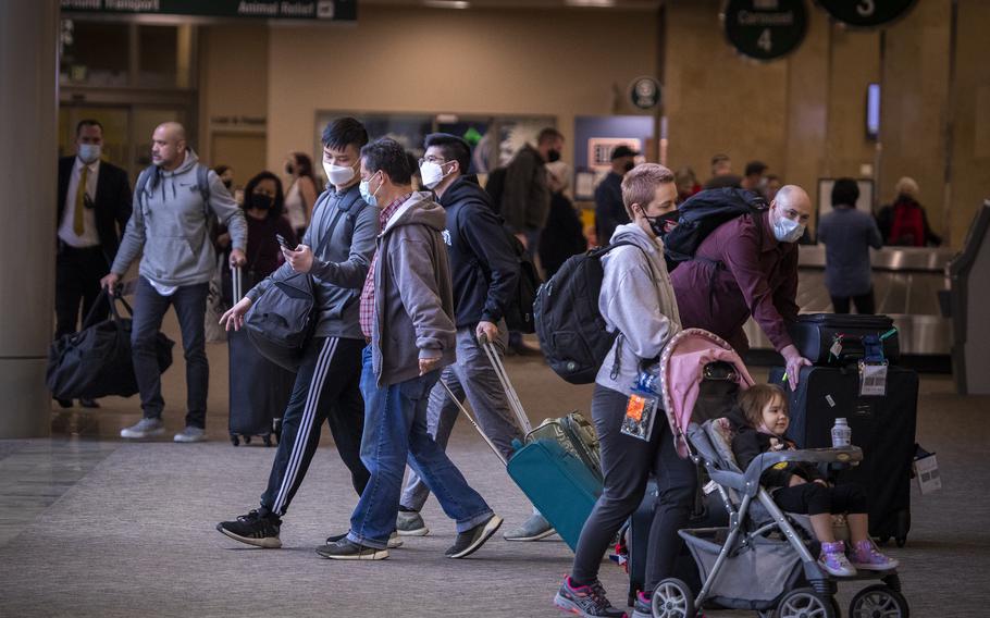 Travelers arrive at John Wayne Airport in Santa Ana, California, on Dec. 21, 2021. 