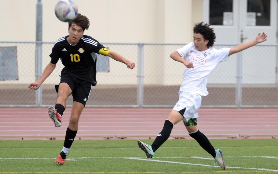 Kadena’s Tyler Smith boots the ball upfield against Okinawa Christian’s Yu Sakane during Wednesday’s Okinawa boys soccer match. The Panthers won 10-1.