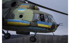 A Ukrainian pilot waves to his comrades from an Mi-8 combat helicopter during a combat mission in Donetsk region, Ukraine, Saturday, March 18, 2023. (AP Photo/Evgeniy Maloletka)