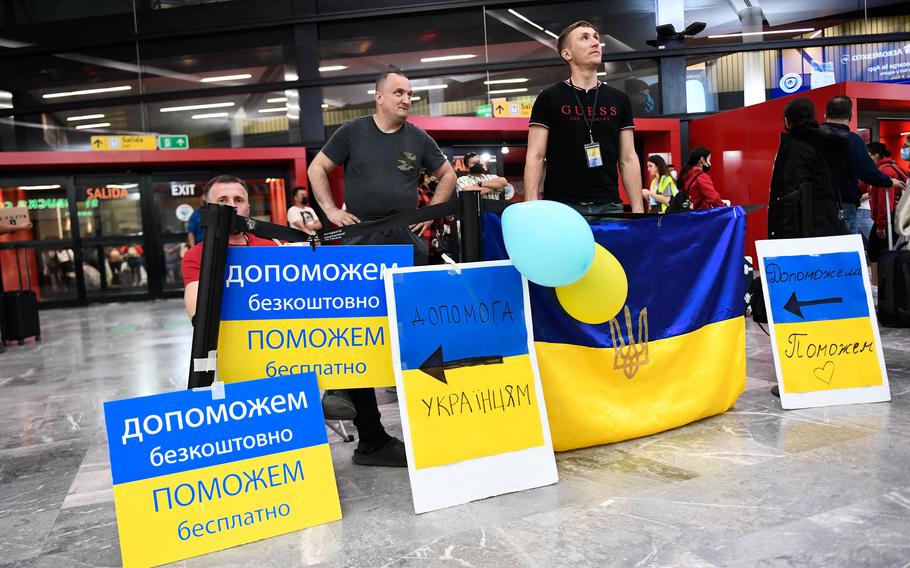 Volunteers with signs welcome Ukrainian refugees as they arrive at the Tijuana airport to help them on their journey to the United States after fleeing the war in Ukraine, in Tijuana, Mexico, on on April 8, 2022.