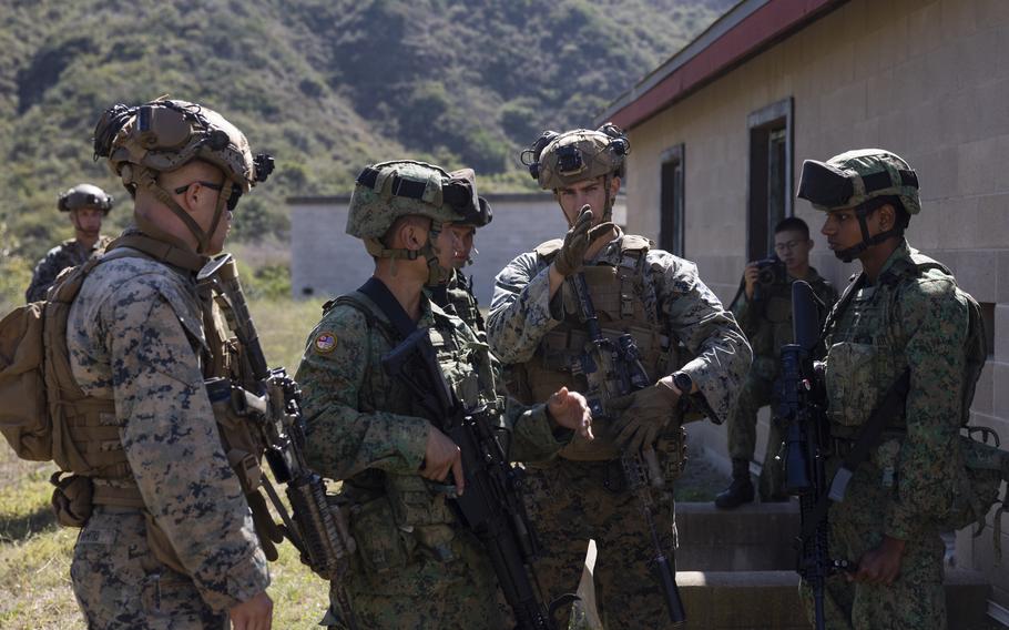 U.S. Marine Corps Cpl. Tristan Weaver, center, a rifleman with 2nd Battalion, 4th Marine Regiment, 1st Marine Division, explains how to maneuver while maintaining security to 7th Singapore Infantry Brigade Guardsmen during Exercise Valiant Mark 2023 at Camp Pendleton, Calif., Oct. 9, 2023. Valiant Mark 23 is an annual, bilateral training exercise conducted between the Singapore Armed Forces and I Marine Expeditionary Force.
