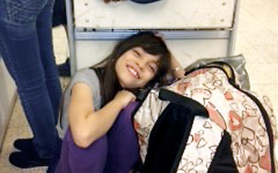Taryn Alexander, 8, rests in an airport terminal in Hawaii as the family waits for a flight back to Yokota, Japan.