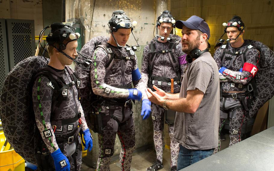 “Teenage Mutant Ninja Turtles” director Jonathan Liebesman, foreground right, discusses a scene with actors portraying mutant ninja turtles, from left, Noel Fisher, Pete Ploszek, Jeremy Howard and Alan Ritchson. For the reboot, the performers donned skin-tight gray getups and shell-shaped backpacks, while helmets equipped with cameras captured their facial expressions. Everything was later replaced on screen with hulking, emoting green avatars.