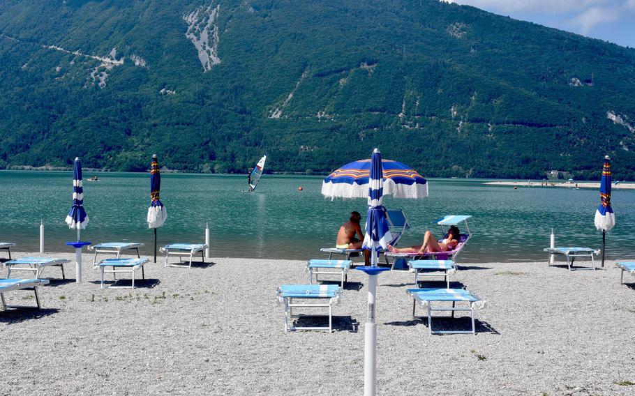 Visitors to Lago di Santa Croce in Italy can rent a chair or umbrella on the pebbly beach - or bring their own.