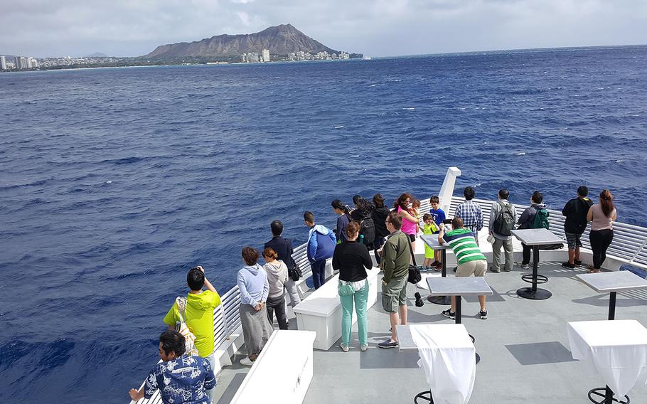 Whale-watchers gather on the bow of the Majestic and search for telltale signs of humpbacks, the most obvious being a water spray made by its blowhole. 