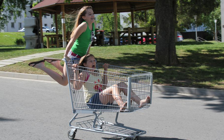 Lisa Smith Molinari's daughters, Anna and Lilly, ride on an abandoned shopping cart when the family was stationed at Patch Barracks in Stuttgart, Germany, in the summer of 2010. 