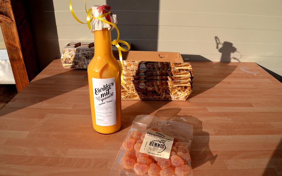 Eggnog and peach gummy candies sit in front of empty egg cartons on a small table near the vending machine at the Kief farm in Hockenheim, Germany, on Nov. 30, 2020. The machine sells only a few products but they are all-natural and of high quality.