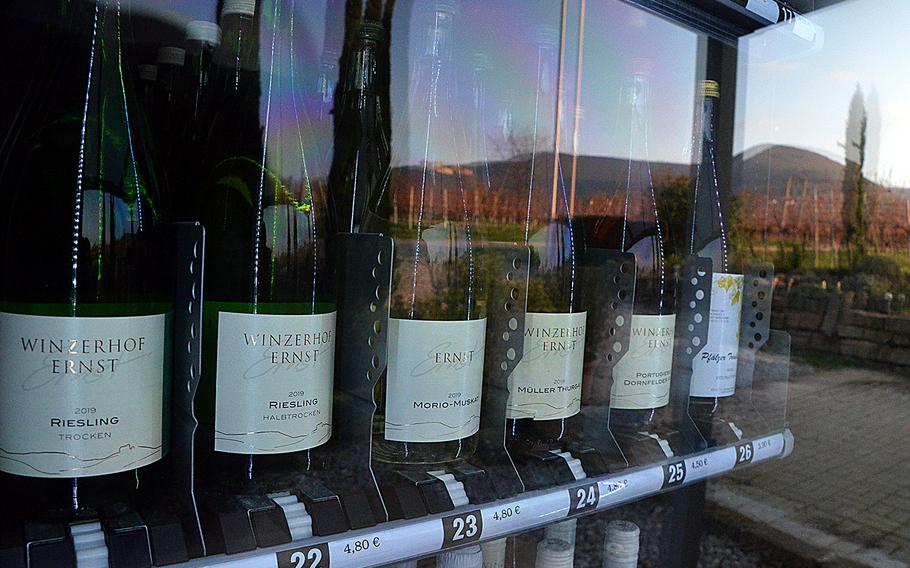 Vineyards and an ancient cloister are reflected in the glass of the wine vending machine at Winzerhof Ernst in Maikammer, Germany, on Nov. 30, 2020. The vending machine sells a selection of reds, whites and roses, along with grape juice, water and glasses to drink them from. 