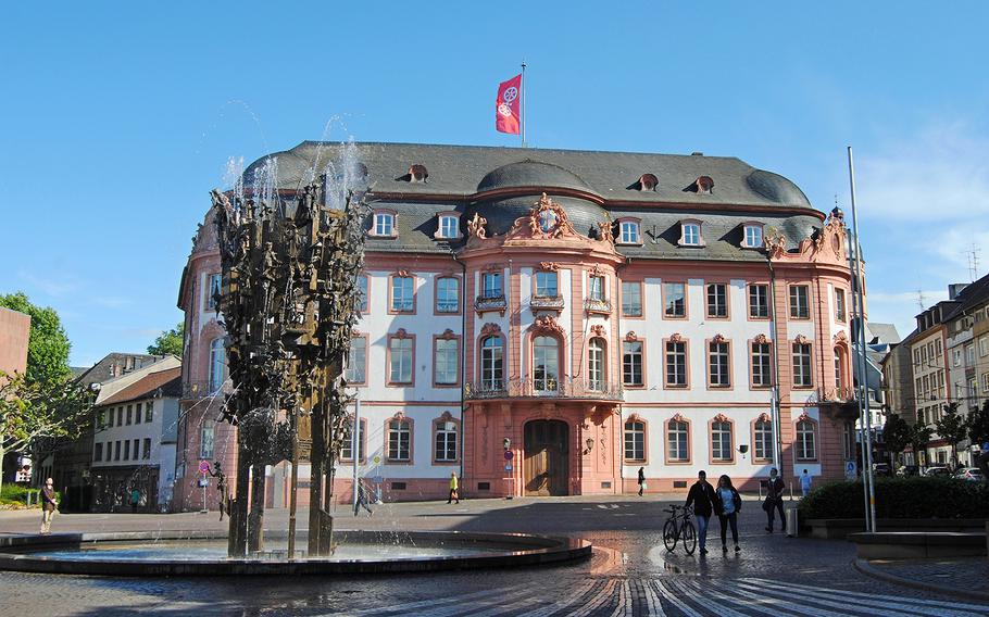 The Fastnachtsbrunnen fountain on Schillerplatz square in Mainz, Germany, is covered with historic buildings and people, including symbols of carnival.