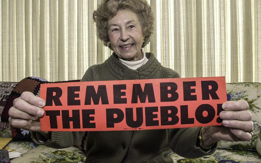 In a February, 2000 photo, Rose Bucher holds up a bumper sticker that she circulated in 1968 in a effort to focus attention on the release of the Pueblo crew.