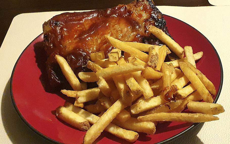 A rack of barbecue pork ribs and a side of fries from Sacellum-Cucineria Urbana in Sacile, Italy.