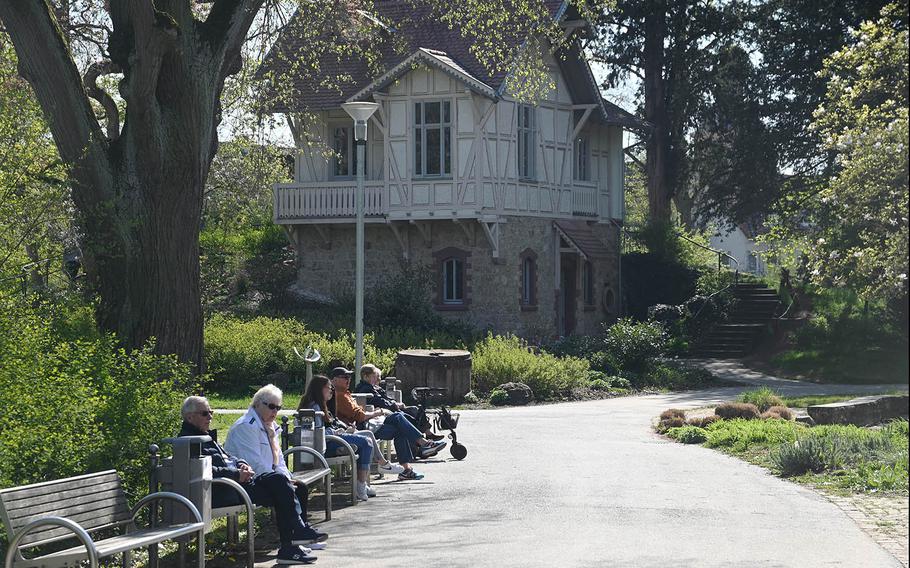 People enjoy a sunny spring day at Verna Park in Ruesselsheim, Germany. In the background is Eremitage,  also called the Alten Muehle, or Old Mill. Not really a mill, Baroness Wilhelmine von Verna, who founded the park, used the building as a retreat. 