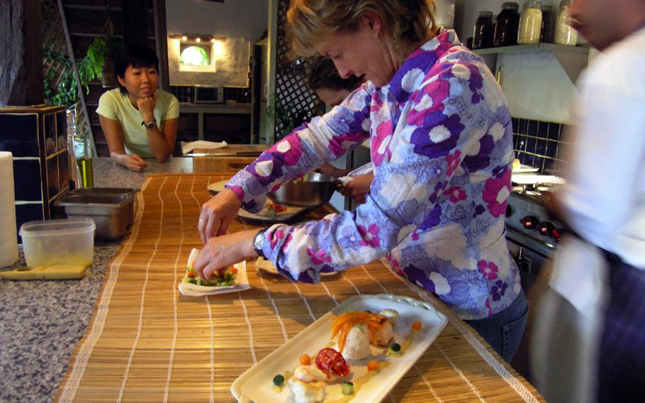 A student at the Walnut Grove Cookery School in Livré, France puts finished food on a plate during one of the school&#39;s classes.