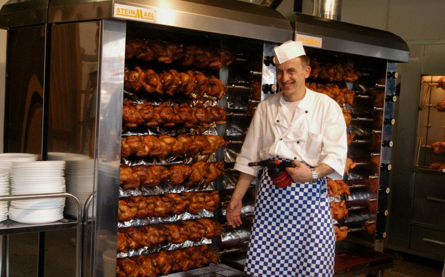 A server broils chickens. He says he will serve about 2,000 chickens per day during the festival.