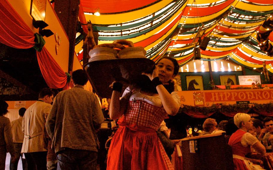 A woman carries plates around the Hippodrom hall, preparing for the thousands of patrons who will be served food along with their beer.