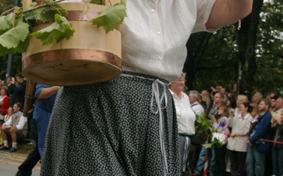 A woman toasts the revelers while marching in the Grand Entry of Oktoberfest Landlords and Breweries, which kicks off he annual festival.