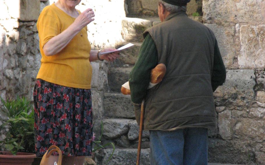 Locals share a laugh on their way home from the Thursday market in Monpazier, France.