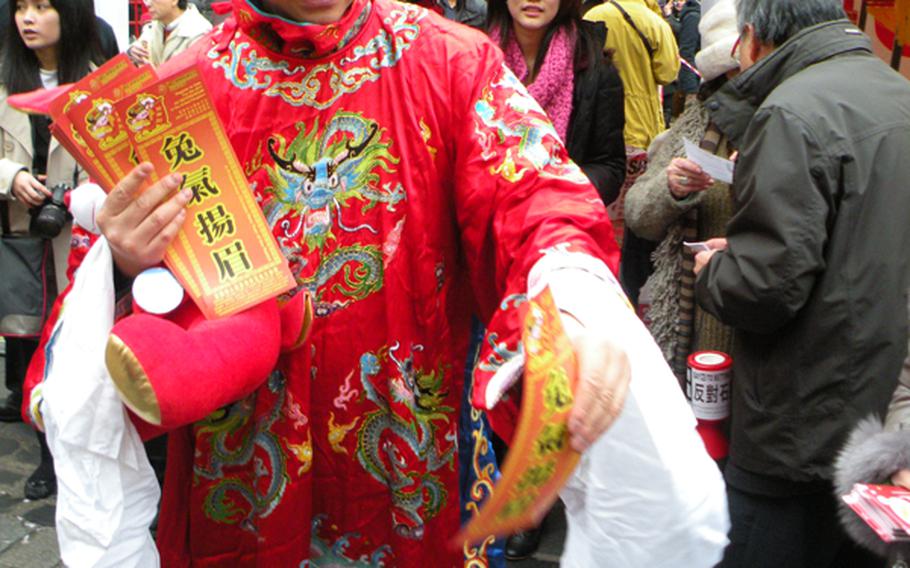 A Chinese man dressed in colorful attire hands out brochures during the Chinese New Year festival in London. The rabbit ears on the man's head signify the start of the Year of the Rabbit on the Chinese calendar.