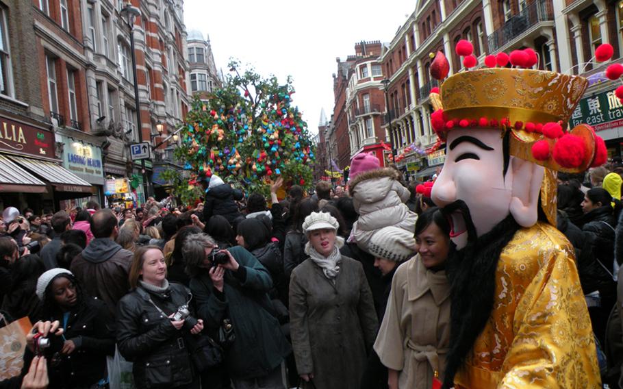 Celebrants pose with a traditional Chinese figure at the Chinese New Year festival Feb. 6 in London.