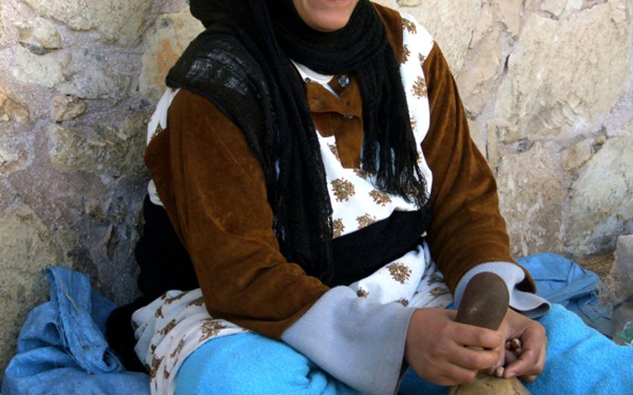 A woman pounds argan nuts to extract an oil that is prized in cooking and cosmetics.
