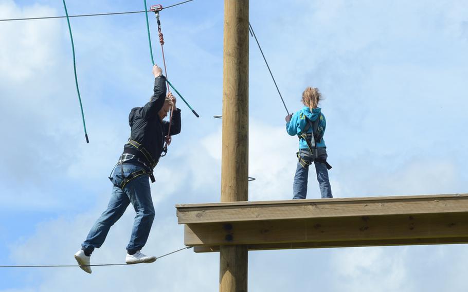 Daniel Matthews gingerly makes his way across the Sky Trek attraction at the Banham Zoo on April 10, 2012 while his 6-year-old niece, Scarlett Norman, waits for him on the platform. The Sky Trek is an obstacle course and zip wire suspended high above the ground. Matthews and his niece are from Louth, England.