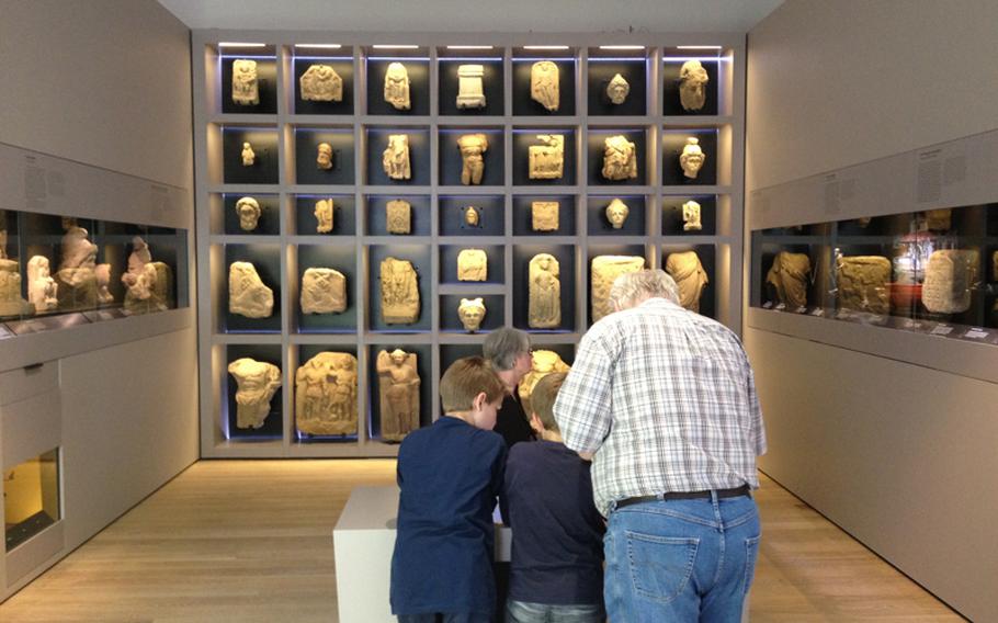Visitors to Landesmuseum Württemberg in Stuttgart, Germany, look over artifacts in a section of the museum about early religions of the Roman Empire on June 6.