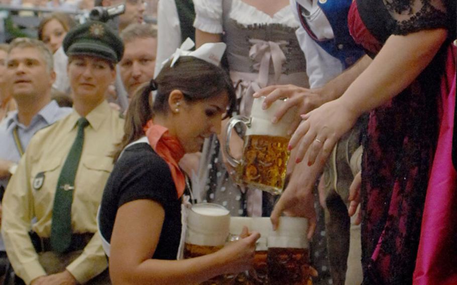 A waitress delivers liter mugs of beer inside the Schottenhamel Festhalle on the opening day of Oktoberfest in Munich. Organizers expect more than 6 million people to attend the festival, which runs through Monday.