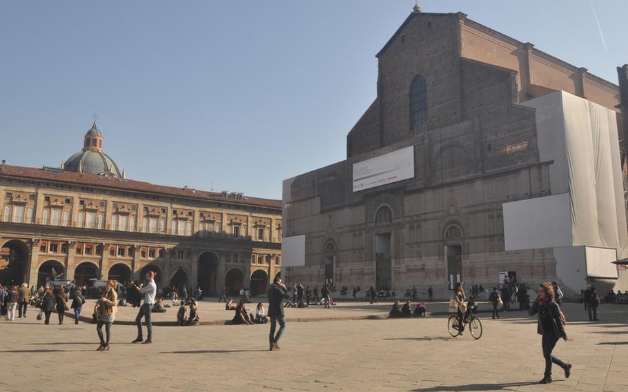 Piazza Maggiore is the main square in Bologna. The facade of the red-brick Basilica of San Petronio, named after the city's patron saint, currently is undergoing restoration. The church was designed to be the largest in the world, but the Vatican funded a university building at the far end of the church while it was still under construction, ensuring it wouldn't be bigger than St. Peter's Basilica in Rome.