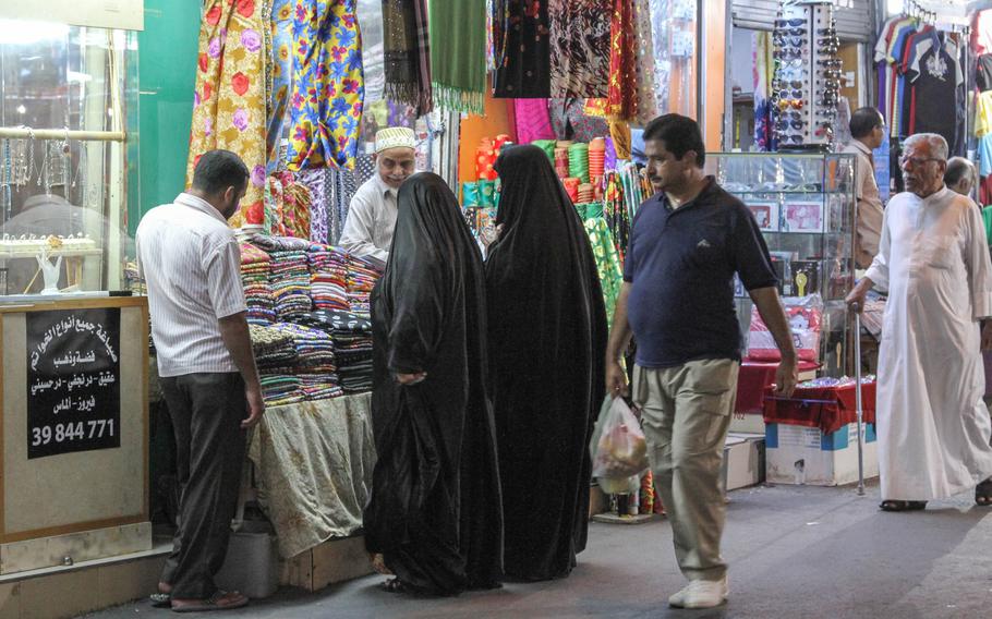 Colorful fabrics tempt two women at one of the shops in the Manama Souq in Manama, Bahrain, on  Sept. 16.