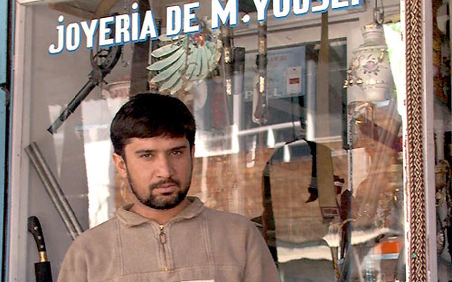 Salesman Ahmed Doud stands in front of the Chicken Street shop owned by his uncle, Mohammed Yousef. Doud calls Yousef "president of Chicken Street."