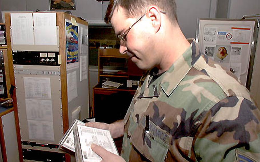 Tech. Sgt. John Tway, NCO in charge of Eagle 810 AM radio, thumbs through CDs in the studio before his daily show, "Retro Cafe," which airs from 10 a.m. to 2 p.m.
