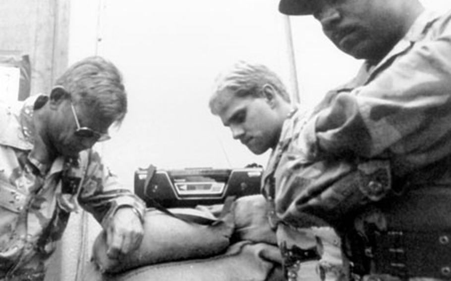 Moments after the launch of F-16C Falcons during Operation Desert Storm, airmen of the 401st Tactical Fighter Wing gather around a radio in 1991.