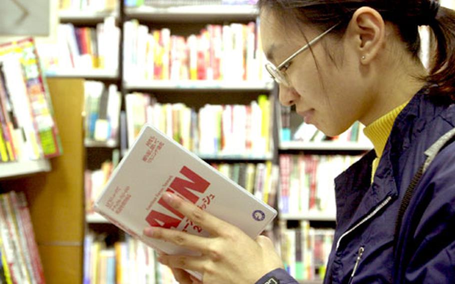 A Japanese book browser checks out a book/CD combo titled “AFN News Flash 2002” in the language section of a Tokyo bookstore. The show is reproduced to help Japanese learn colloquial English.