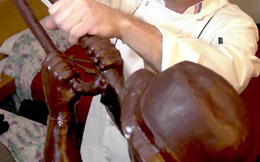 Sgt. 1st Class Dave Russ puts the finishing touches on a 3-foot-tall chocolate sculpture in his hotel room at the Avisse Parc Hotel in Luxembourg.