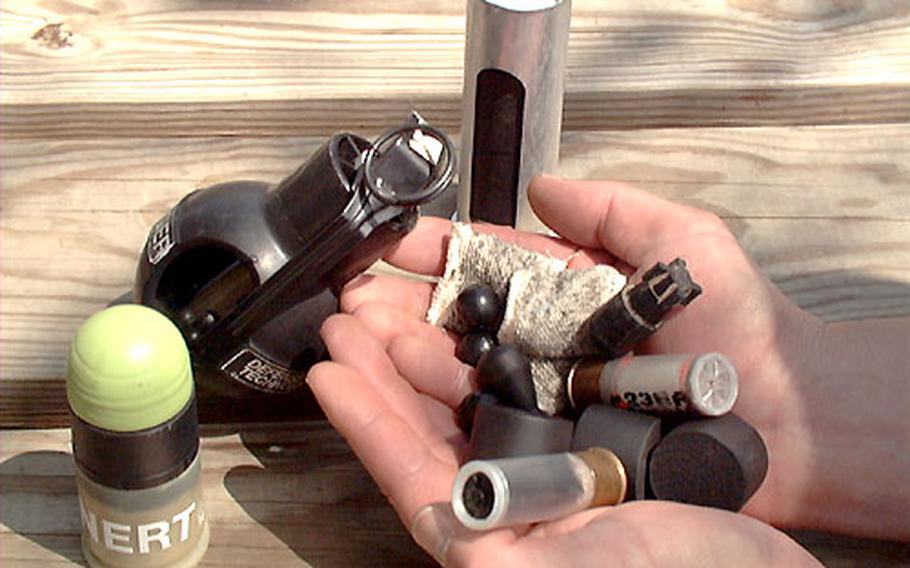An instructor at the Interservice Non-Lethal Weapons Instructor Course at Fort Leonard Wood, Mo., shows a variety of nonlethal munitions, such as rubber bullets, tear gas canisters, and wooden pegs. Some of the munitions are are designed to be fired from standard military weapons like the M-16, while others demand their own special delivery devices.