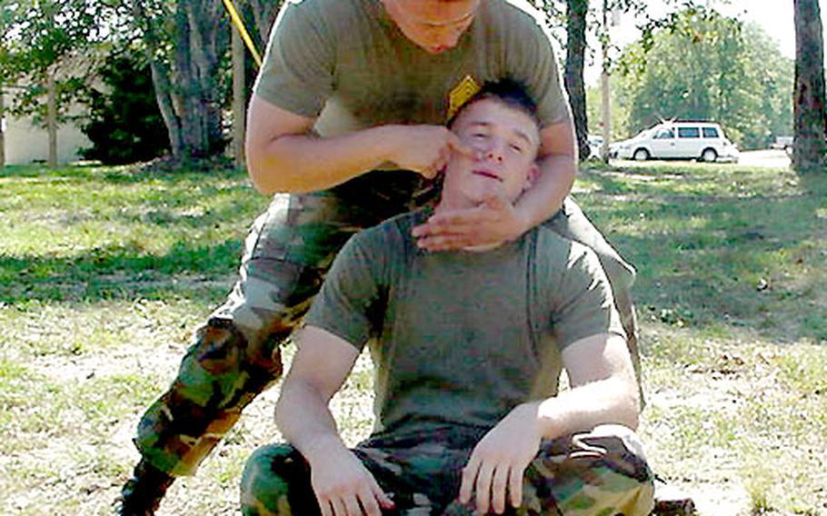 In addition to being exposed to pepper spray, students learn other techniques for subduing unruly civilians. Here, an instructor teaches students how to apply pressure to facial nerves.