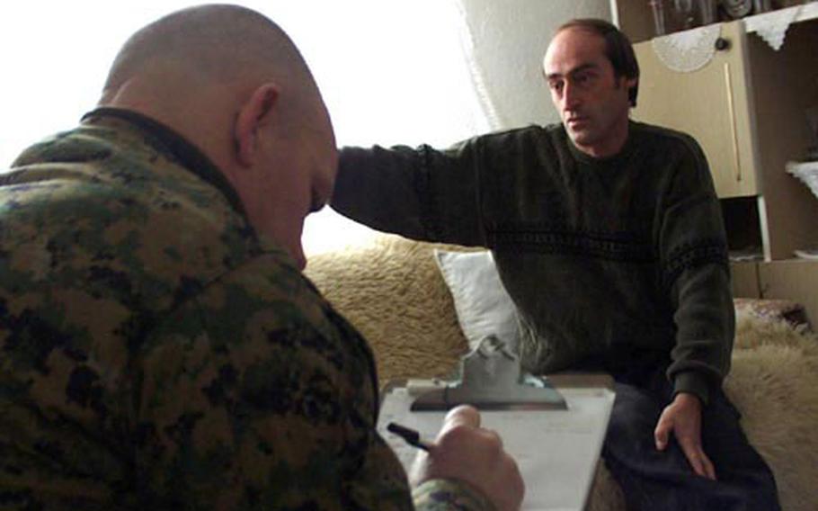 Marine Maj. John Church Jr., left, takes notes as Sabit Shrnu, an Albanian, is interviewed in his home by another Marine. Church is part of the 415th Civil Affairs Battalion at Camp Bondsteel and on Tuesday they talked with Shrnu, a village leader about his living conditions and what help his community needs.